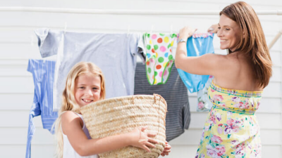 Kobieta z dziewczynką wieszające pranie