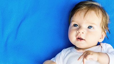 Ein Baby mit blauen Augen und blauem Hintergrund.