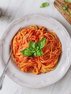 Une assiette de spaghetti avec des feuilles de basilic