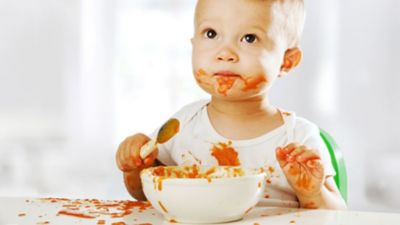 Baby isst Spaghetti und ist voller Flecken