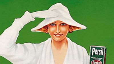 Vintažinio „Persil“ reklaminio plakato detalė: žaliame fone - moteris, vilkinti balta suknele ir skrybėle, laikanti „Persil“ pakuotę.
