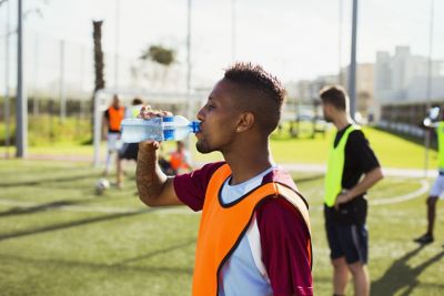 uomo che beve da una bottiglia di acqua