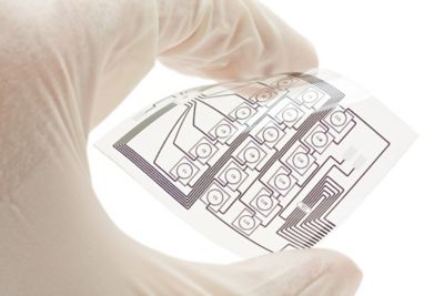 Photo of white gloved technician holding a flexible printed circuit manufactured with printable conductive ink suitable for moisture sensing  medical and hygiene products shutterstock ID 78922045
