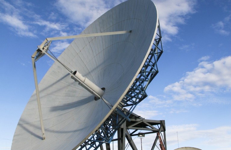 Photo of large grey satellite dish with blue sky and clouds in the background cropped shutterstock ID 22571947