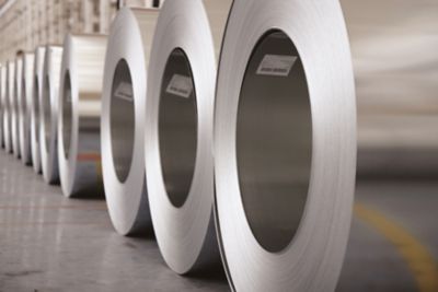 Rows of numerous sheet metal rolls in a warehouse