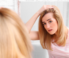 Woman inspecting her hair in mirror for breakage