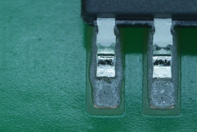 Closeup photo of SOIC small outline integrated circuit leads in wet solder paste