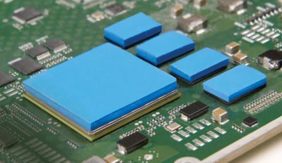 Photo of blue thermal interface material on components on a green pcb