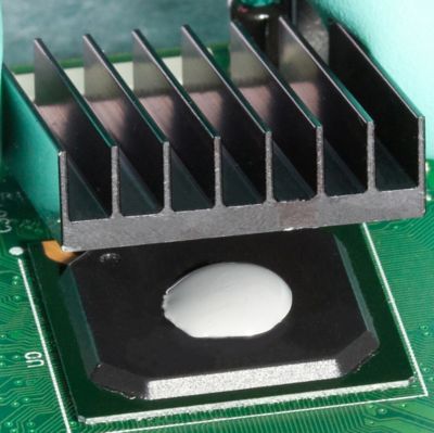 Photo of white dot of thermally conductive adhesive applied between electrical component and heatsink for heat dissipation