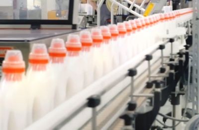 Boce proizvoda Persil Sensitiv na proizvodnoj traci prikazuju održivu ambalažu