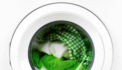 Okvir perilice rublja napunjen bijelim i zelenim rubljem