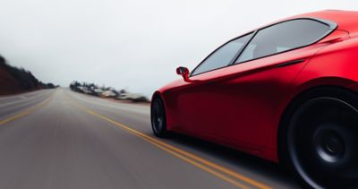 View of red driver's side of a car driving down a highway