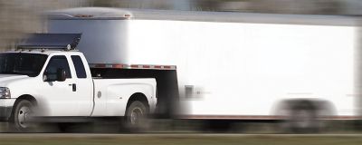 Work truck with trailer attached driving on a highway