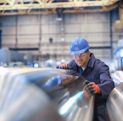 Ingenieur in der Fabrik, der die Metallspule begutachtet